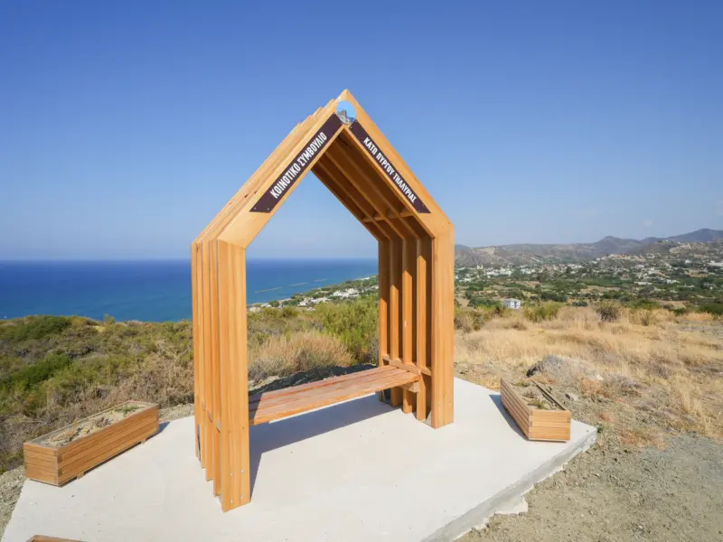 Wooden frame and bench at the Kato Pyrgos Viewpoint overlooking the sea